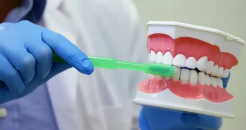 Brosse à dents souple et dentifrice sur un lavabo clair