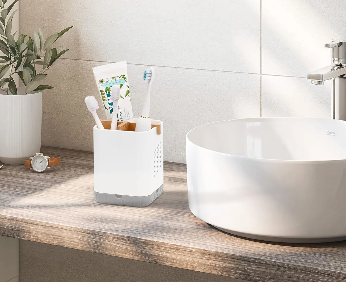 Brosse à dents à poils souples et dentifrice posés sur un plan de vasque