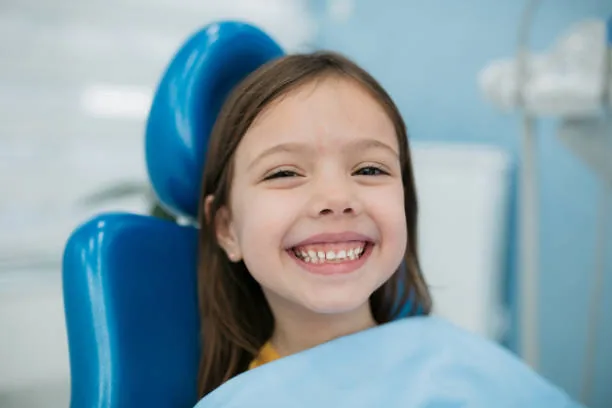 Jeune patiente souriante au fauteuil dentaire